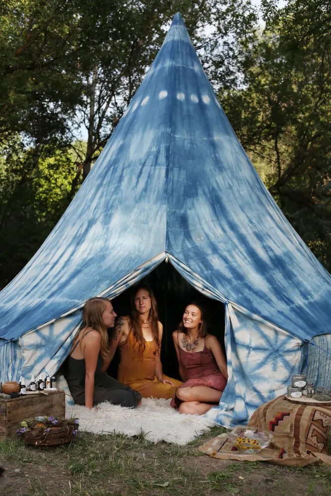 Three women inside an indigo-dyed tent, North Fork Valley